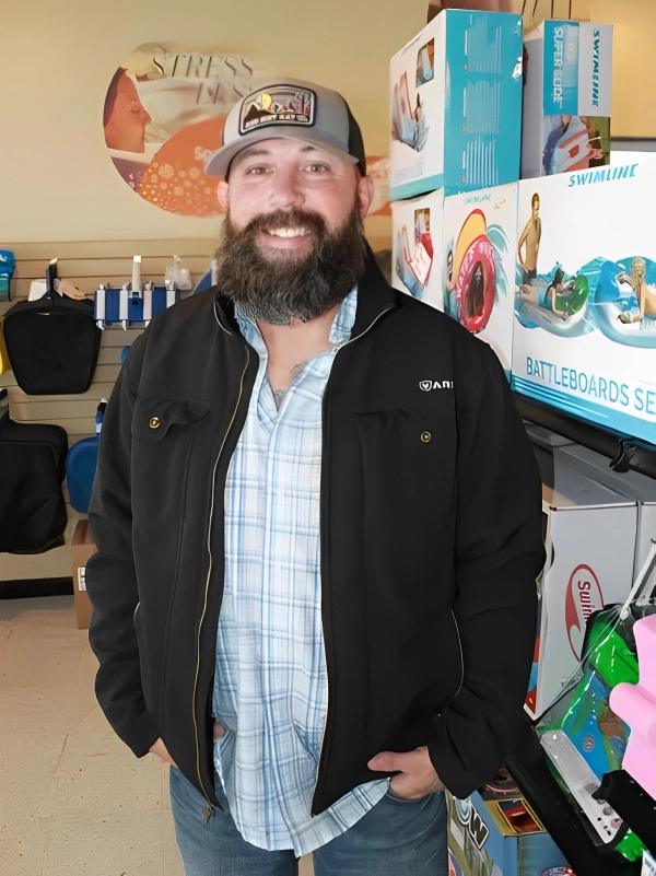 Man in black jacket smiling in store.
