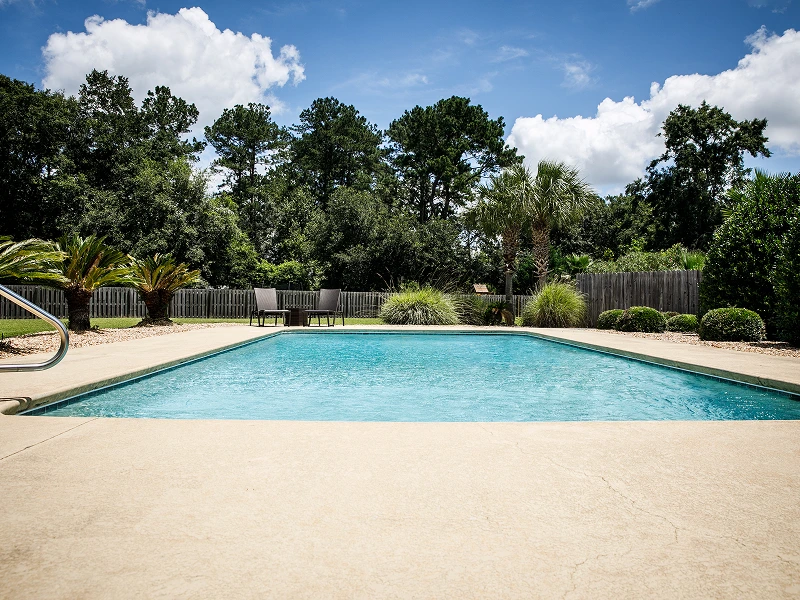 Inviting backyard pool with lounge chairs.
